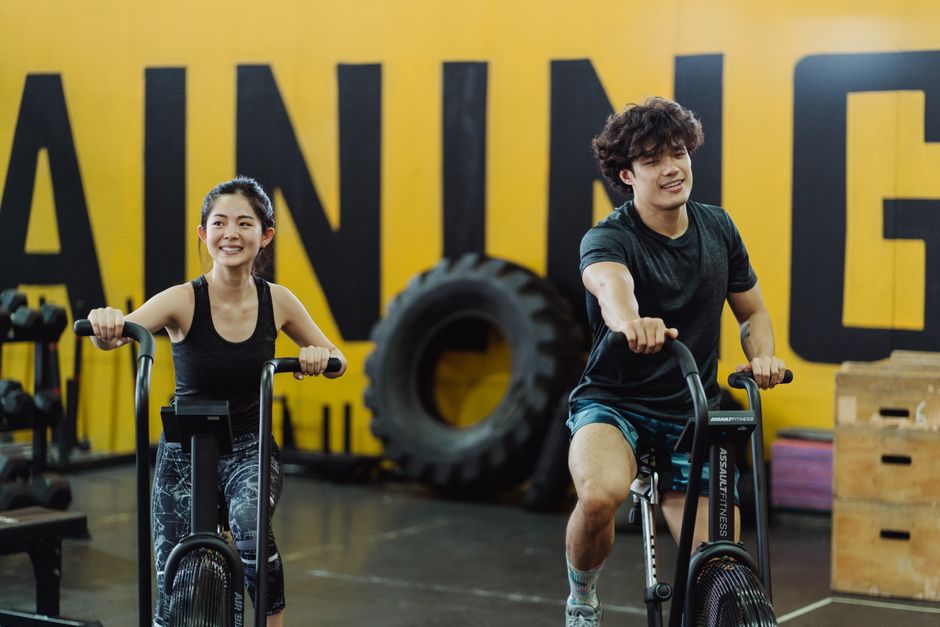 Happy couple enjoying indoor cycling workout.