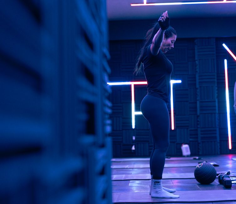 Fitness enthusiast exercising in a stylish neon-lit studio