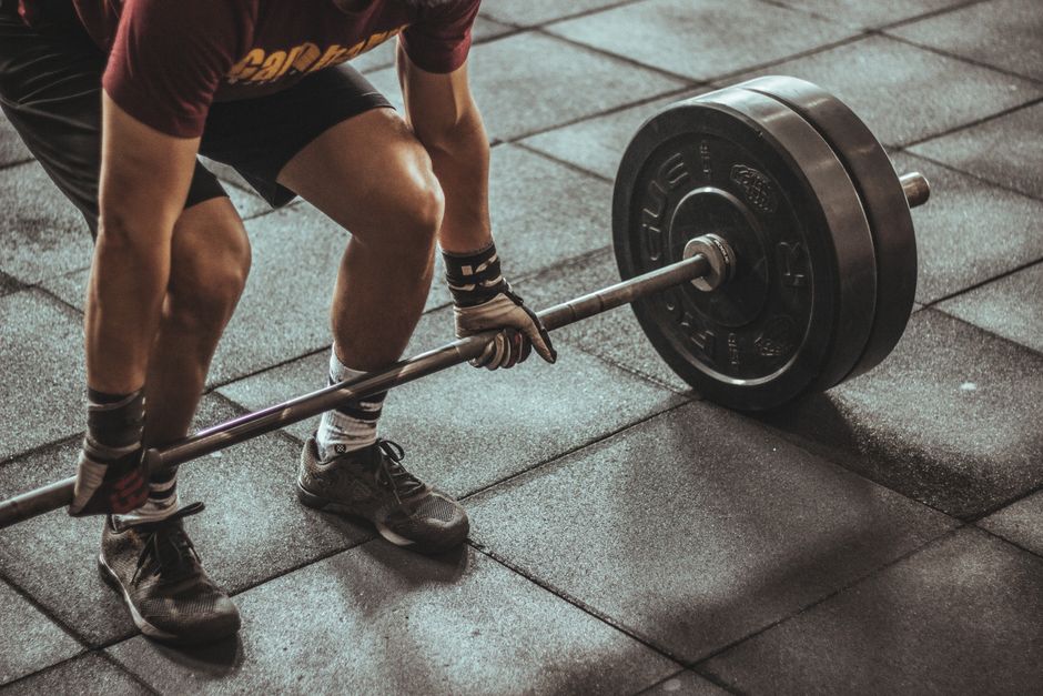 A focused weightlifter prepares to lift a heavy barbell.